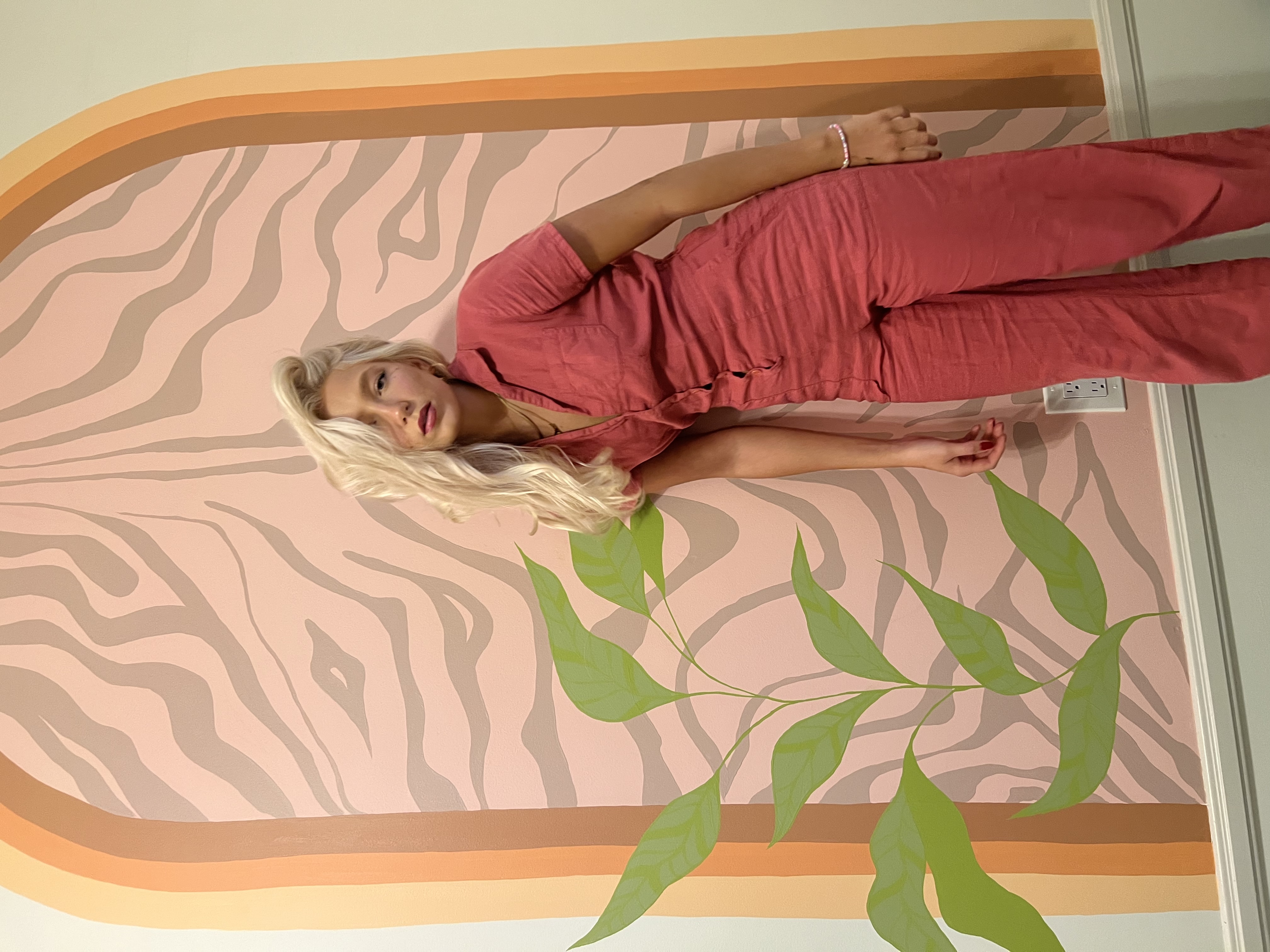 Karis standing in front of her mural